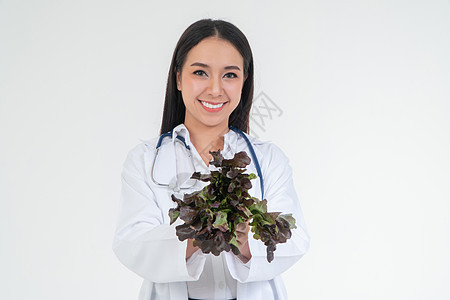 医生或营养师拿着新鲜蔬菜 在诊所里微笑 健康饮食 营养食品的概念作为身体健康的处方 蔬菜是药物图片