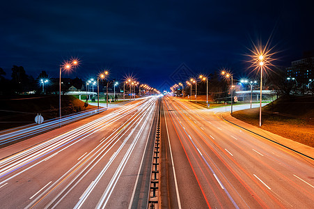 夜间在高速公路上从汽车和街灯发出的明灯图片