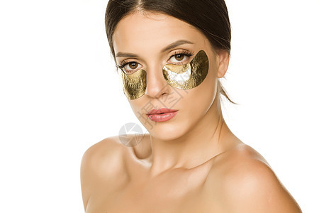 女人的眼皮下 披着金发眼罩女性眼睛卫生温泉补丁化妆品产品金子皮肤图片