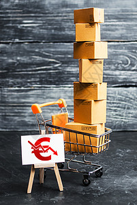 装满箱子和带有欧元符号向下箭头的标志的购物车 货物销售和零售收入减少 购买力下降 降价 打折图片