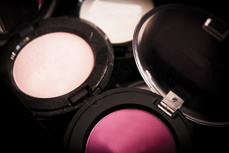 暗底背景上的各种化妆阴影调色板成套产品工具皮肤魅力粉末袖珍棕色口红图片