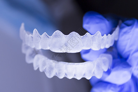 牙医手举行的牙齿矫正术白色塑料病人固定器隐适支撑矫正药品工具微笑图片