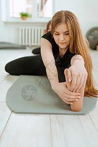 伸展运动 健康的生活方式 穿着黑色制服的年轻漂亮女孩正在做伸展运动 Akroyoga 瑜伽 健身 锻炼 运动班级训练俱乐部灵活性图片