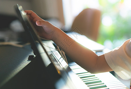 小男孩在家弹钢琴和音乐平板电脑闲暇音乐家乐器教育练习旋律药片男生孩子钢琴家图片