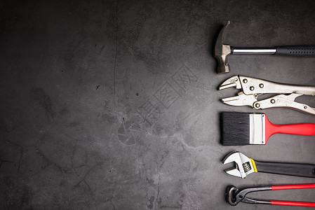 水泥灰色背景的家用修理手工具 概念之家职业硬件地板乐器修理工钳子螺丝刀装修地面钥匙图片