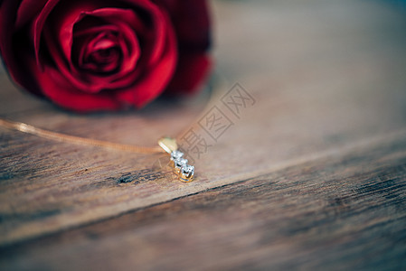 情人节木地板上的红玫瑰花戒指叶子项链花瓣纪念日婚礼女士桌子周年婚姻图片