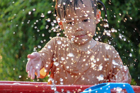 可爱的亚洲小女孩玩得开心 在夏令营里玩水喷水管公园家庭女孩孩子们童年浴缸女性飞溅微笑洒水器图片
