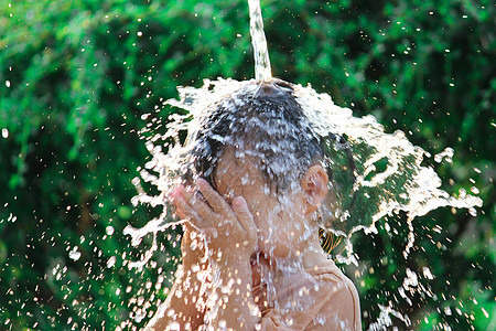 可爱的亚洲小女孩玩得开心 在夏令营里玩水喷水管飞溅公园家庭晴天孩子们女性女孩花园微笑软管图片