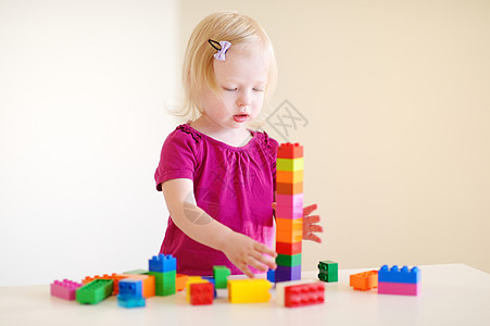 可爱的幼儿女孩玩多彩街区游戏积木家庭房间创造力女性快乐学习建筑动物育儿图片