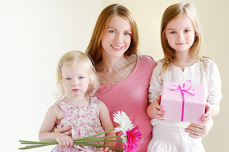 母亲和女儿给与礼物姐姐庆典快乐丝带花朵家庭盒子包装假期周年图片