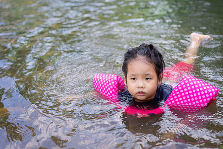 河里游泳孩子小亚洲女孩在河里游动乐趣公园白色幸福森林假期微笑石头岩石孩子背景