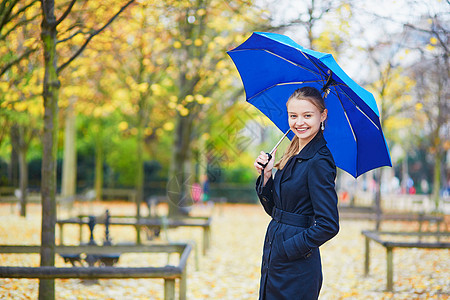 秋天或春季下雨日 在卢森堡巴黎花园的卢森堡花园中带蓝伞的年轻女子花园街道叶子蓝色季节沉淀天气女孩城市预报图片