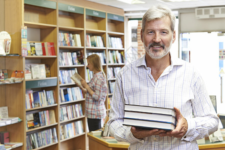 男书店主与背景客户的男性图书店主肖像成人文学图书馆微笑女性销售男人女士两个人店铺图片