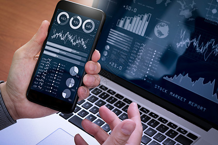 投资者使用商业智能 BI 和关键绩效指标 KPI 分析股市报告和财务仪表板 商务人士使用智能手机和笔记本电脑钥匙战略投资智力交换图片