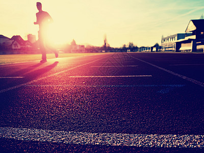 高个子跑在体育场的红色赛道上射线车道短跑游戏运动装运动服运动日落裤子草地图片