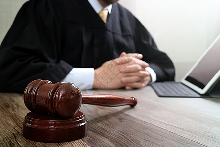 司法与法律概念 在法庭上 用手锤的男法官惩罚思考顾问男人电脑药片成人刑事软垫锤子图片