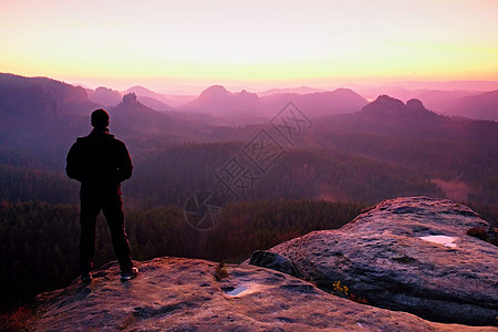 在悬崖上高高的黑人 看着日出登山 假扮自信心游客运动力量阳光太阳男性旅行远足者成就自由图片