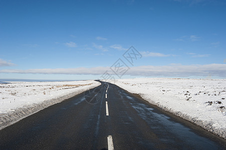穿过冬季农村地区乡村地带的乡村公路草地蓝色天空白线旅行沥青场地英语消失图片