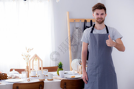 一个微笑的男性厨师在Kitc 上展示访问标志的肖像图片
