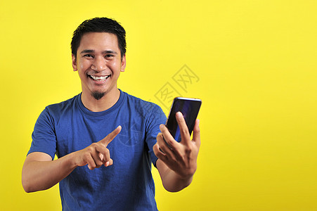 快乐的年轻英俊帅气的亚洲男人笑着用智能手机微笑触摸屏网店人士商业电商电话手势互联网幸福社会图片