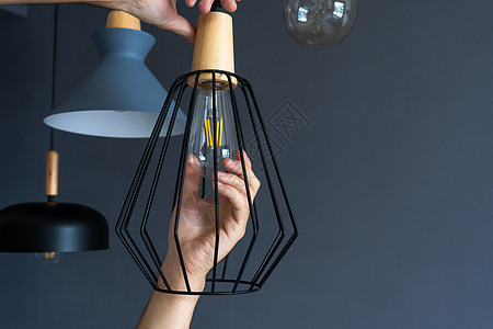 特写 手会改变一个灯泡 在时尚的阁楼灯 螺旋丝灯 现代室内装饰阁楼技术电气活力玻璃生态白炽灯插座家务安装拧紧高清图片素材