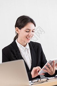 一位女商务人士专心致志地和幸福地工作微笑眼镜文档衬衫商业工人企业家桌子电脑人士图片