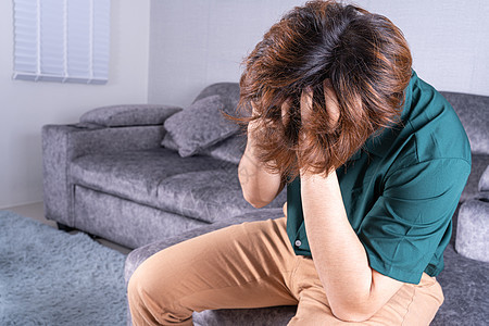 青年男子坐在沙发上时头部疼痛 保健医疗或日常生活概念 在家庭里 男方需要照顾孩子压力药品伤害头痛失败疾病偏头痛情感身体成人图片