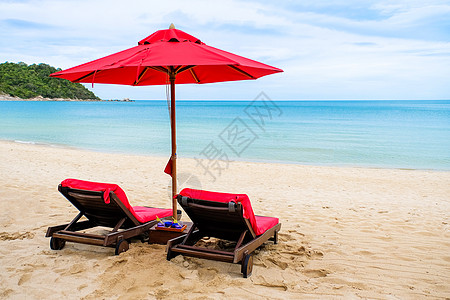 红伞在沙滩上闲暇休息天堂日落晴天太阳躺椅游客椅子旅游图片