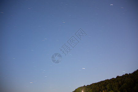 蓝夜天空有星星绿色地平线地球天篷树木科学天体云带宇宙蓝色图片