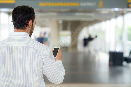 一名商务人士使用手机智能手机的后视镜男人商务电话技术屏幕人士男性电子邮件细胞互联网图片