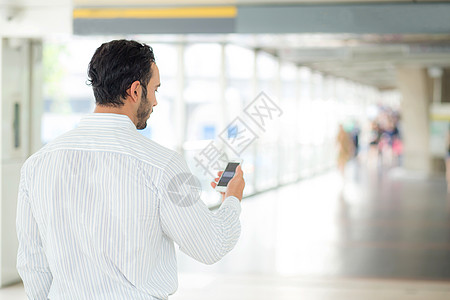 一名商务人士使用手机智能手机的后视镜电子邮件短信细胞空白电话男人商务男性技术人士图片
