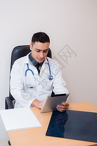 医生在他的办公室使用平板电脑男人药品医疗工具软垫外科职业触摸屏电子医院图片