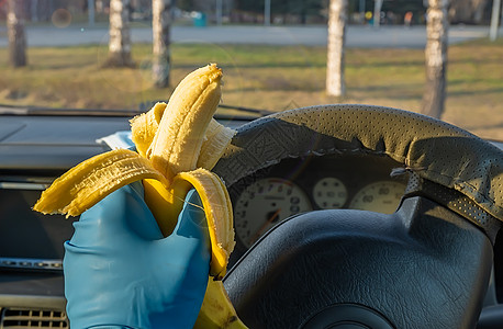 快速安全的食物 汽车司机手里的香蕉营养恐慌冒险手套车轮小路疾病危害运输生物图片