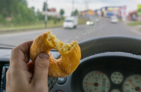 食品 饼干 甜甜面包圈 在汽车司机手里图片