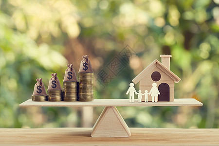 房地产投资和房屋抵押贷款概念 木屋 家庭成员和美国钱袋 在木天平秤上一排排上升的硬币上 描述住宅的家庭财务管理图片