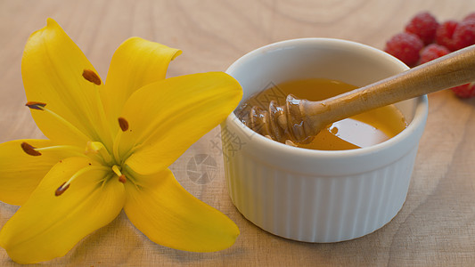 蜂蜜汤匙加蜂蜜工具勺子味道百合覆盆子宏观晴天琥珀色生态花园图片