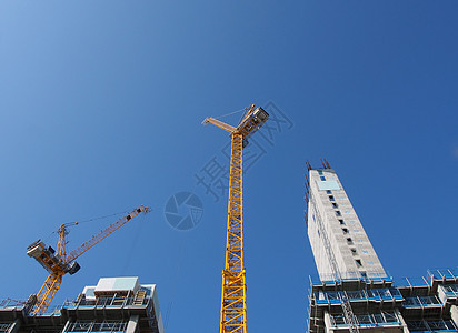 a 显示在大型建筑工地工作的高塔起重机对准英格兰的蓝天空投资机械景观技术城市公寓办公室工程财产建筑学图片