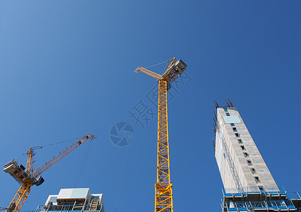 a 显示在大型建筑工地工作的高塔起重机对准英格兰的蓝天空摩天大楼景观天空投资公寓职场项目办公室生长住房图片