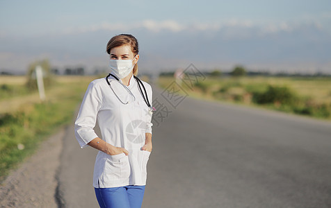 家庭医生女医生或护士在农村公路旁边戴防护面罩 身着防护面具安全女士专家感染保健医师口罩女性卫生药品背景