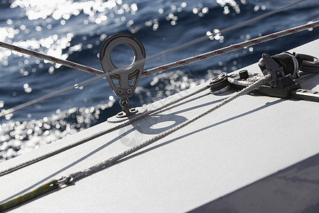 游艇贴近时的绳索绞盘宏观曲柄血管夹板码头蓝色电缆假期奢华金属图片