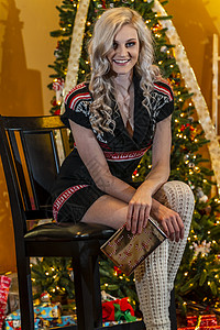 可爱的年轻金发模特儿 在家里享受节假日 圣诞树 礼物和圣诞树庆典女孩装饰惊喜元素美丽假期魅力微笑女性图片
