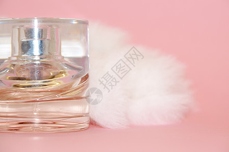 粉红背景的香水瓶和白皮芳香女性液体瓶子魅力产品惊喜个性健康广告图片