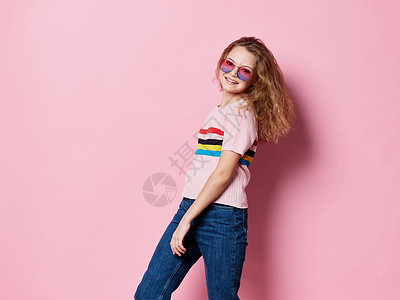 戴着眼镜的快乐女孩和穿着粉红色背景笑容的条纹T恤图片