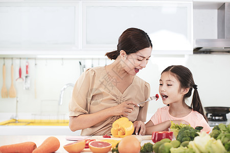 母亲和儿女在吃蔬菜和水果时幸福地享用着蔬菜和水果父母女性营养沙拉午餐女儿厨师厨房家庭帮助图片