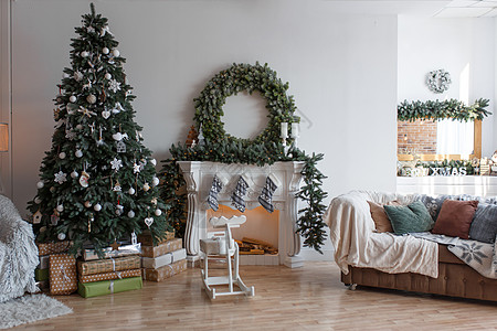 时尚的现代圣诞装饰 一个小舒适的房间工作室礼物装饰品季节沙发新年盒子公寓花环庆典图片