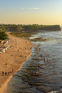 印度尼西亚巴厘岛巴兰甘海滩的魔术日落蓝色悬崖橙子海滩海浪天空酒店冲浪平房奢华图片