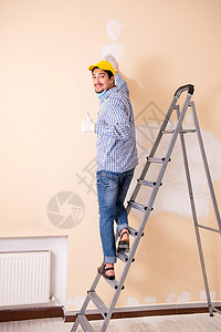 年青的承包商用砂纸铺沙墙画家房子磨料承包商工人维修装修服务修理工绘画图片