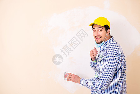 年青的承包商用砂纸铺沙墙工人装潢画家磨料绘画承包商修理工工具工作房间图片
