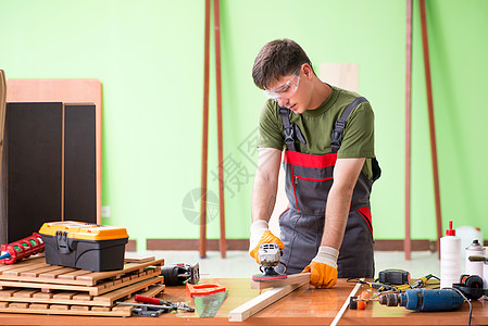 在工作间工作的青年木工工人手工木地板机器乐器地面服务维修家具装修修理工图片