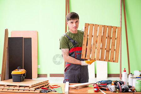 在工作间工作的青年木工工人木匠乐器木地板工具服务展示工匠工作台维修木头图片